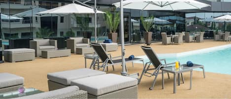Piscine extérieure, parasols de plage, chaises longues