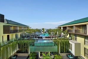Hotel amb piscina central, zones d'estar a l'exterior i balcons.