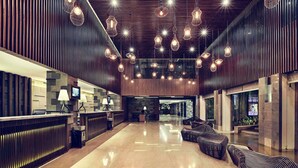 Un vestíbulo amplio con mostrador de recepción, zona de estar e iluminación moderna.