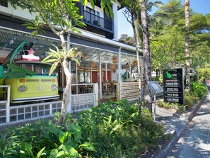 A restaurant with a vintage VW camper, outdoor seating, and a sign listing food and drink options. - Mercure Bali Legian (Legian)