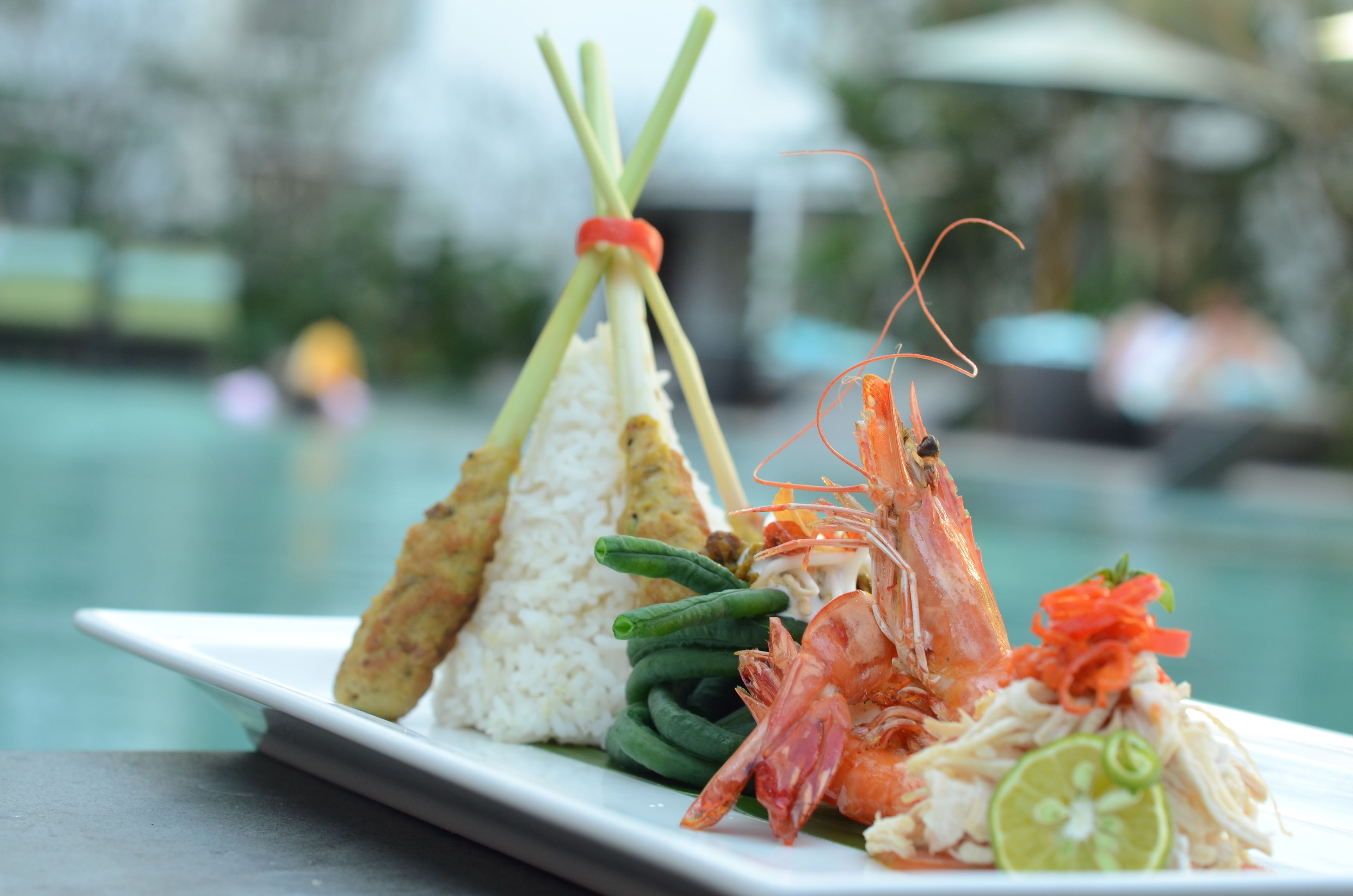 Une assiette de nourriture comprenant des crevettes, du riz et des légumes.