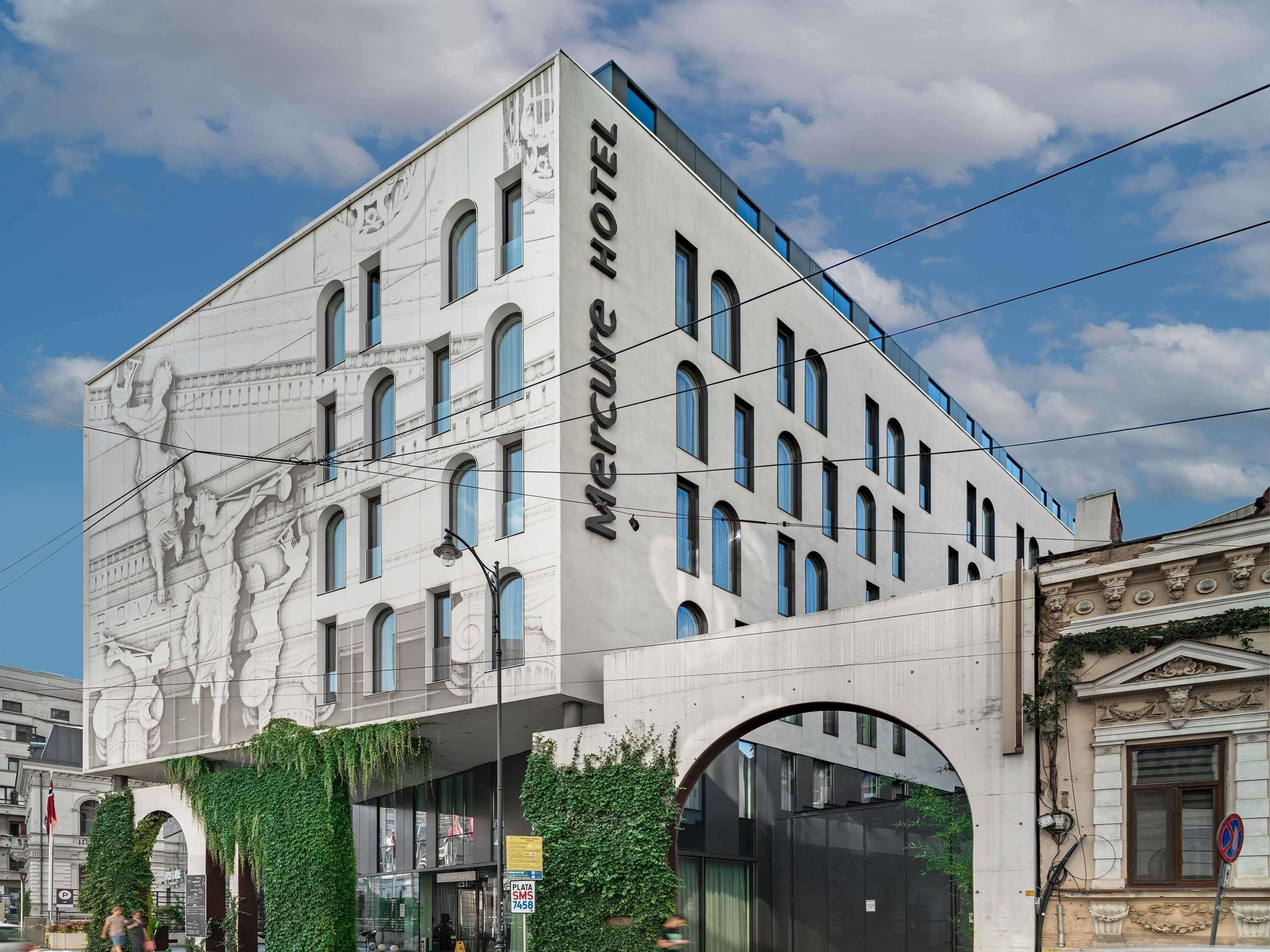 Ein Hotel mit einer klassischen Fassade, zahlreichen Fenstern und einem großen Rundbogenportal.