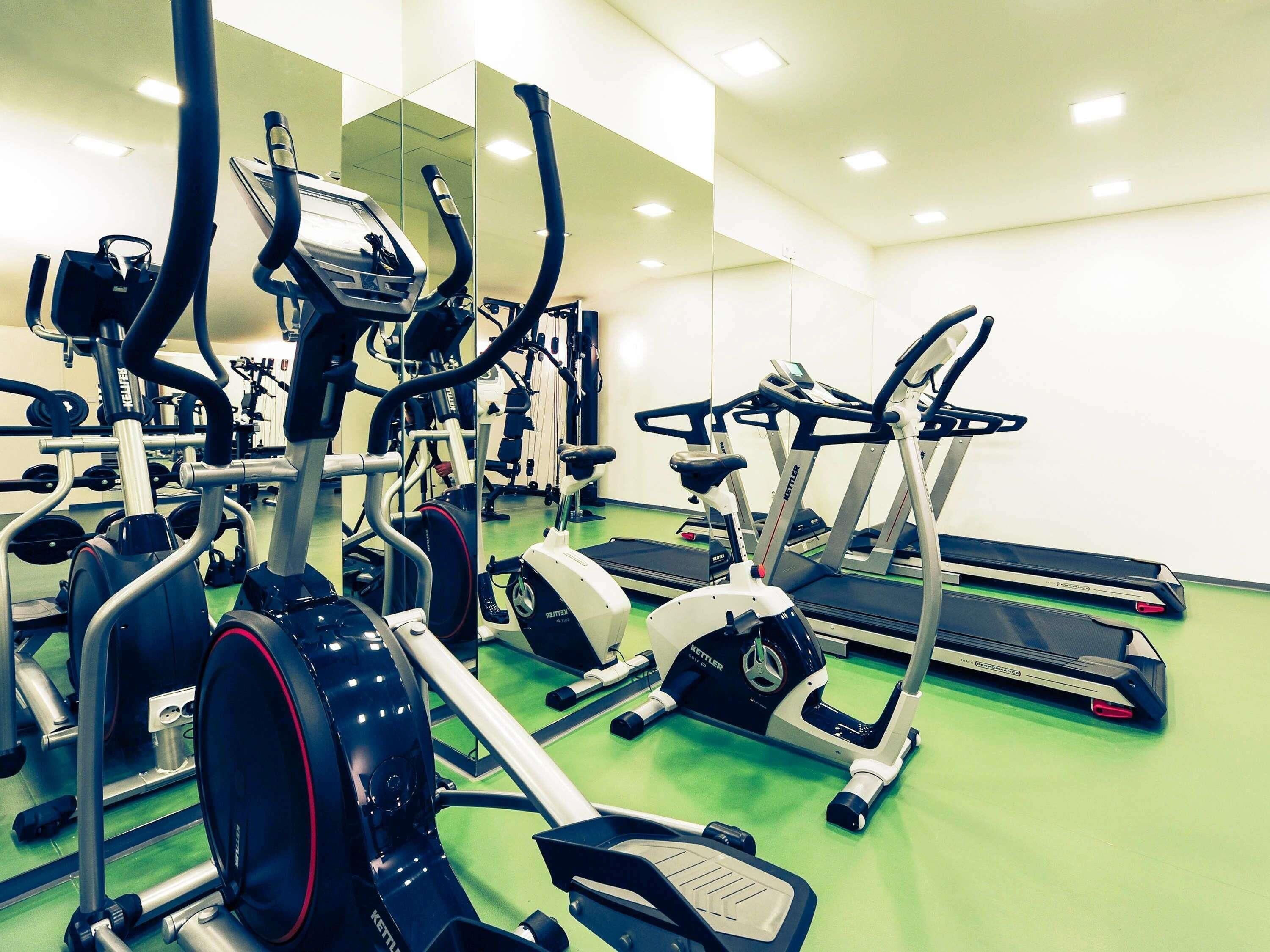 Ett gym med olika typer av konditionsmaskiner, inklusive löpband och crosstrainers.