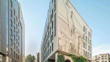 Stunning building with a central entrance and symmetrical design, featuring a large mural.