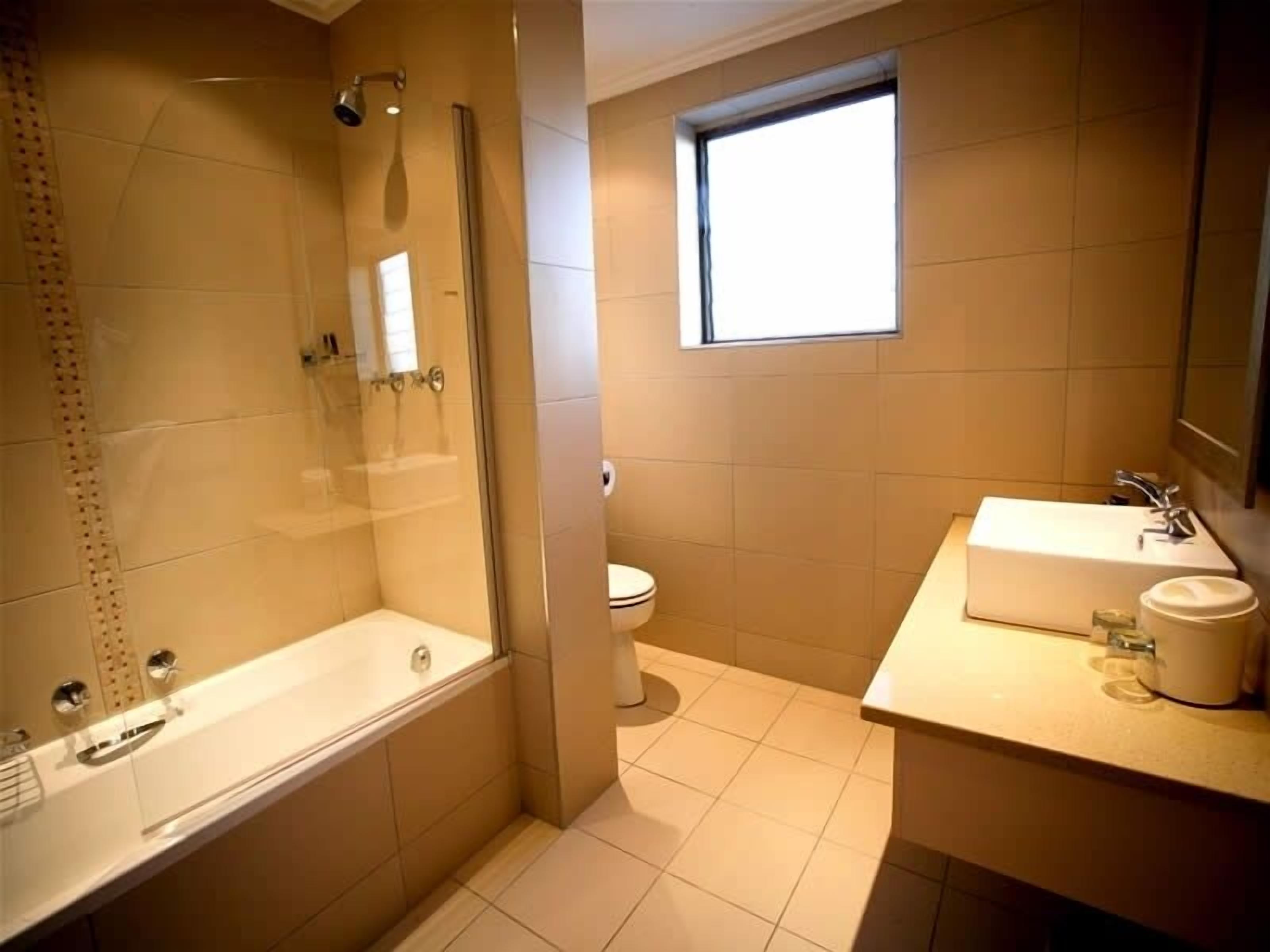A modern bathroom with a bathtub, toilet, and sink.