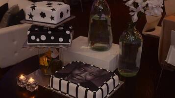 Una mesa con un pastel, velas y un jarrón con flores.