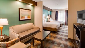A hotel room with a sofa, a small table, a TV, and two beds. - Best Western Plus Atrium Inn & Suites (Clarksville)