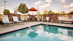 A pool area with lounge chairs, a stone wall, and a no diving allowed sign. - Best Western Plus Atrium Inn & Suites (Clarksville)