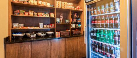 Un espace proposant des distributeurs automatiques de collations et de boissons, avec un assortiment varié de produits.