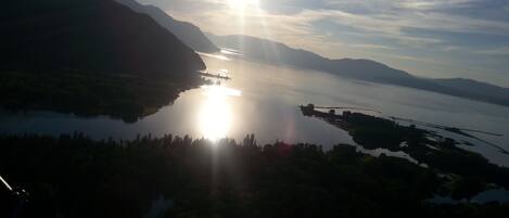 A panoramic view of a lake with mountains in the background and a clear sky.