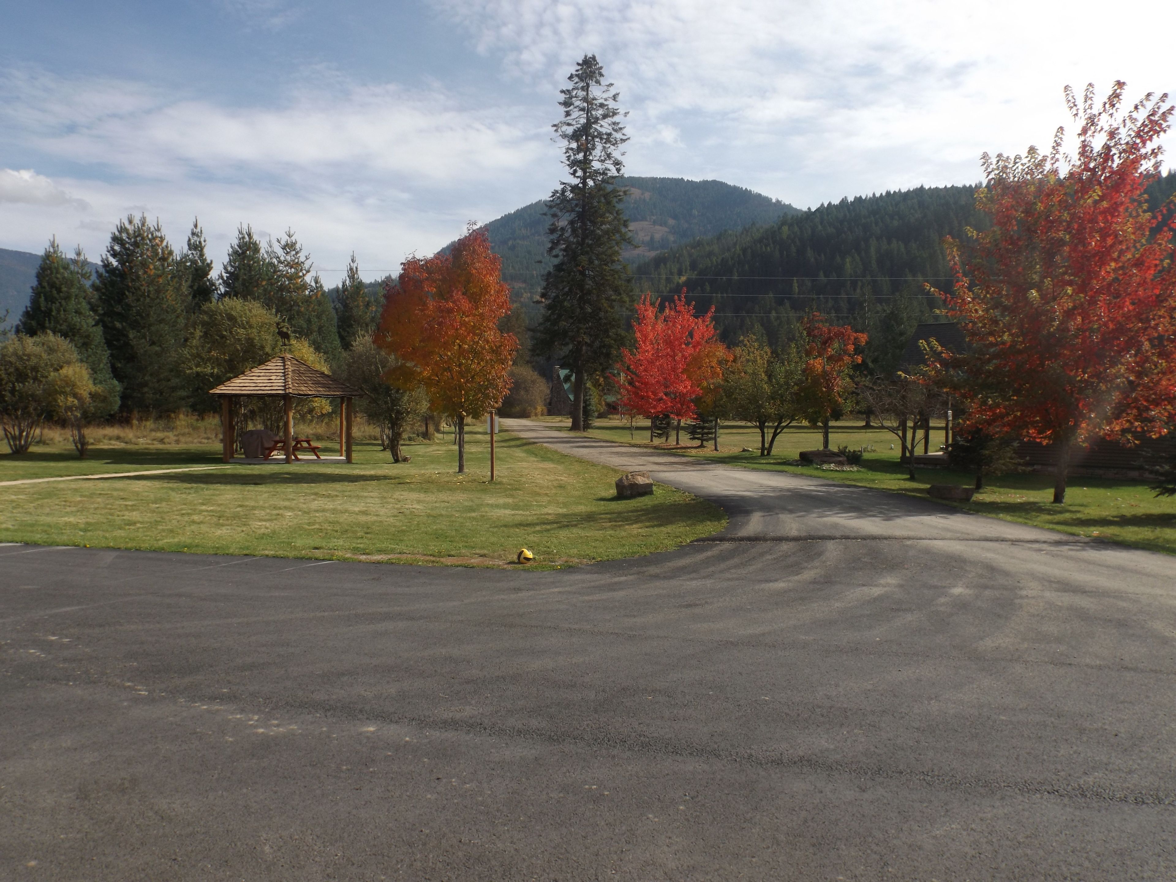 A park with a gazebo, picnic tables, and a paved path.