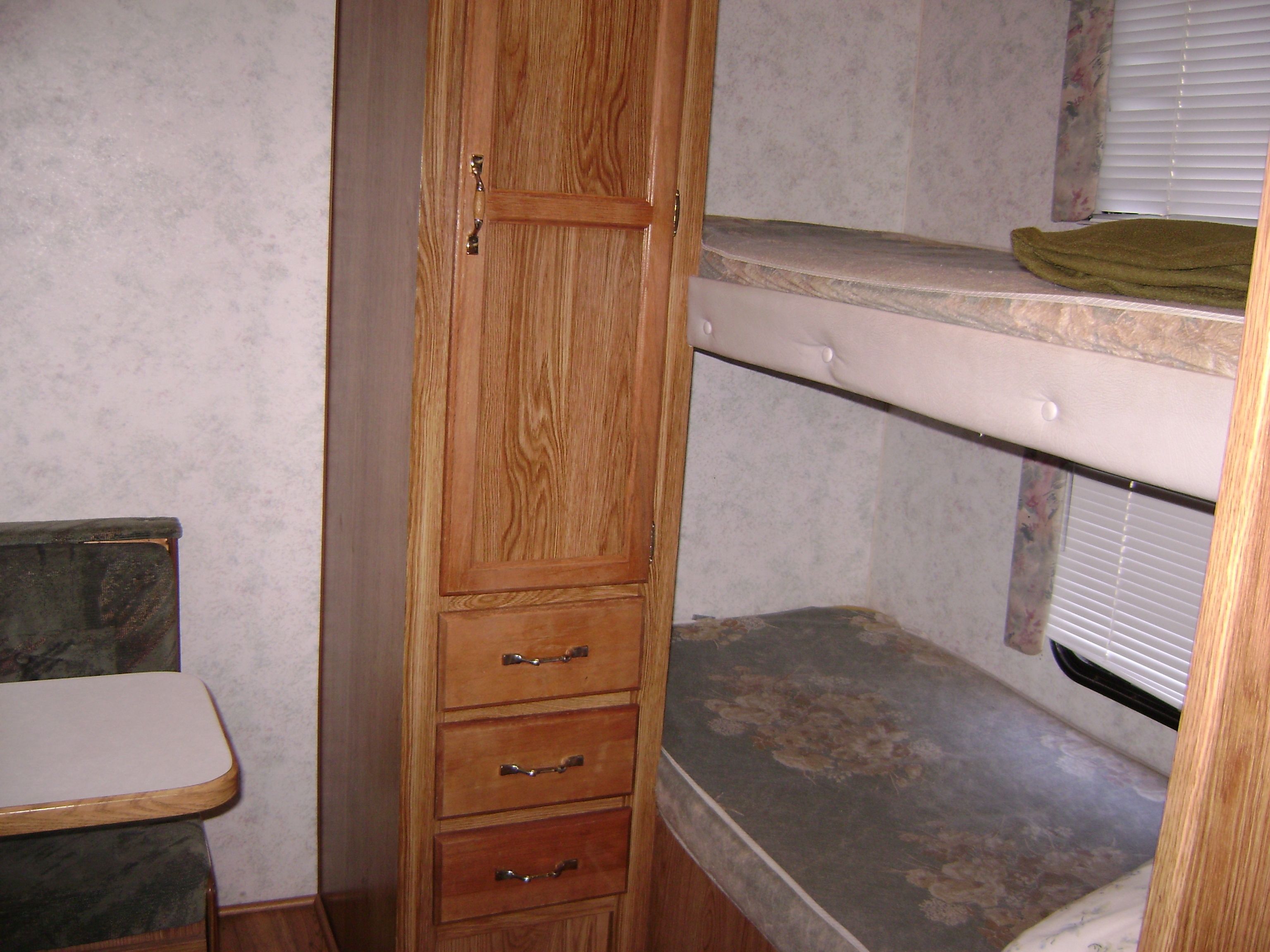 A compact room with a wooden cabinet, a small table, and a bench.