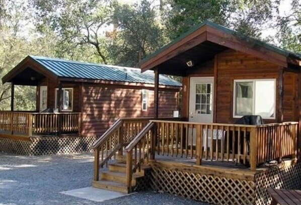 A wooden cabin with a porch and a covered deck area.