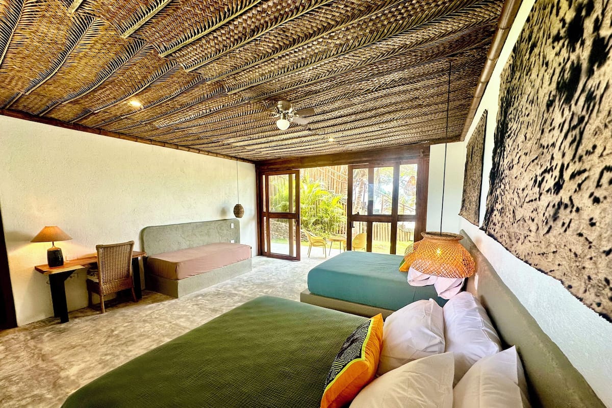 Una habitación con dos camas, un escritorio y una silla.