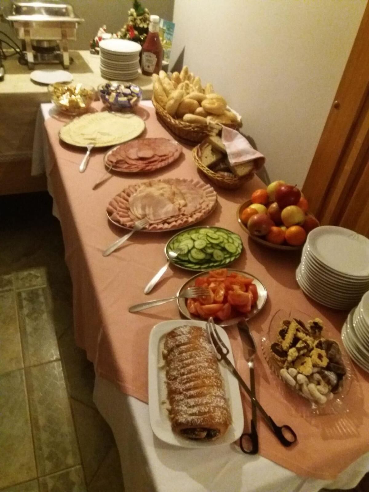 A buffet table with various food items including pies, bread, fruits, and vegetables.