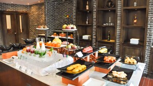 A buffet with various food items and beverages, including fruits, vegetables, and desserts, arranged on tables and shelves. - THE PRIVILEGE FLOOR by Lotus Blanc (Siem Reap)