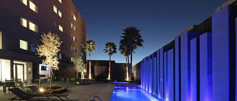 Alberca al aire libre y camastros