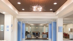 A spacious lobby with a modern ceiling design, a reception desk, and clear signage for amenities like a fitness center and breakfast area. - Holiday Inn Express & Suites Temple - Medical Center Area by IHG (Temple)