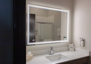 A modern bathroom with a large mirror, a sink, and a shower area. - Holiday Inn Express & Suites Temple - Medical Center Area by IHG (Temple)