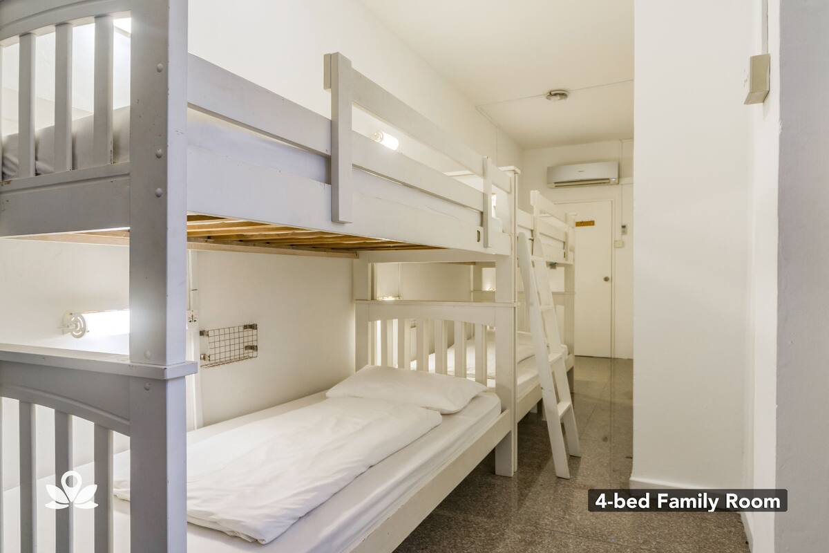 A 4-bed family room with bunk beds, a white color scheme, and a visible air conditioning unit.