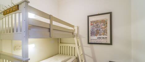 A bunk bed room with a framed poster on the wall.