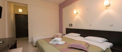 Habitación de hotel con dos camas, un escritorio y una silla.