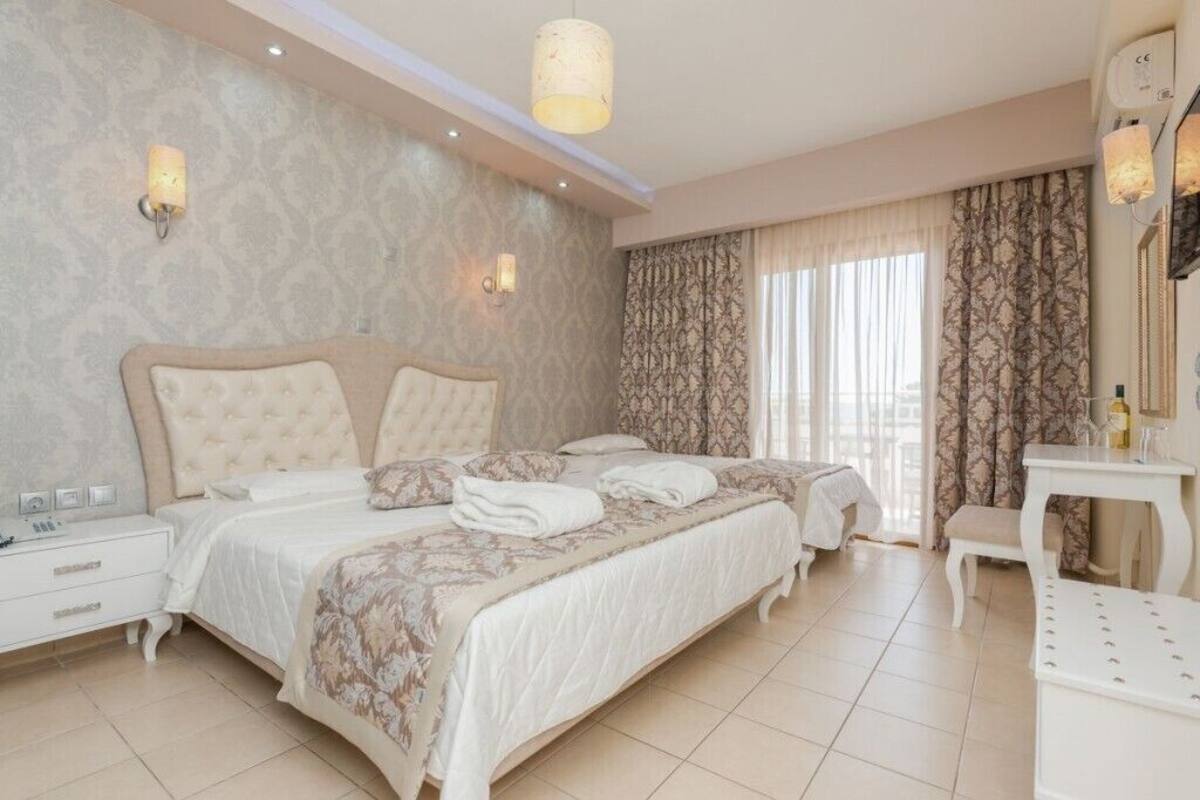A hotel room with a large bed, a bedside table, a chair, and a mirror.