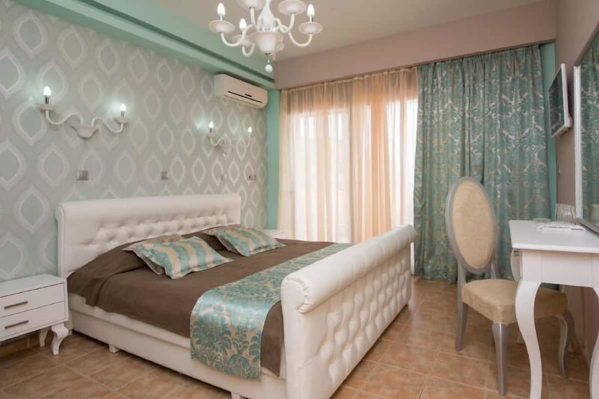 A bedroom with a bed, bedside table, chair, and a desk with a chair.