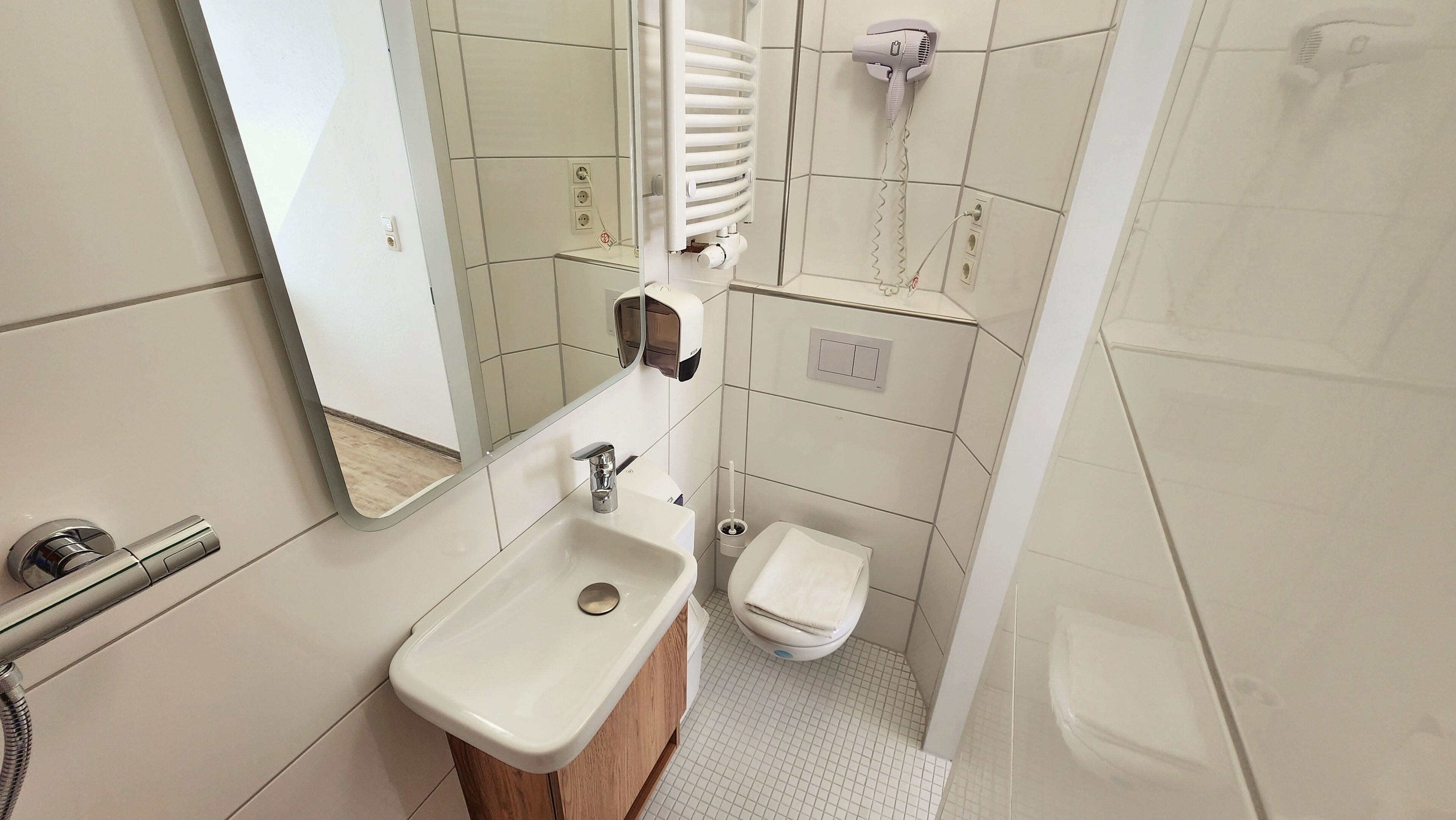A bathroom with a sink, toilet, and a shower area.