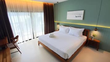 Una habitación de hotel moderna con una cama grande, un escritorio y una silla.