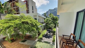 Un bâtiment moderne doté d’une cour intérieure agrémentée d’un petit étang où nagent des carpes koï, de mobilier en bois et d’une végétation luxuriante.