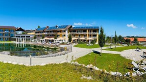 A hotel with multiple floors, outdoor pool, and sun loungers. - Hotel Nesselwanger Hof (Nesselwang)