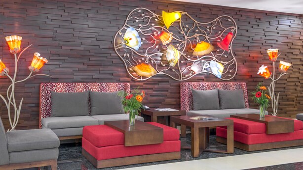 A modern lobby with two sofas, a coffee table, and a decorative wall piece.