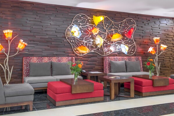 Un vestíbul modern amb dos sofàs, una taula de cafè i una obra decorativa a la paret.