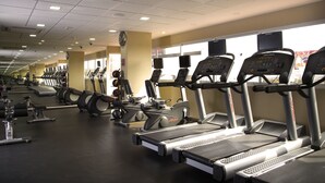 A gym with multiple treadmills, stationary bikes, and rowing machines.