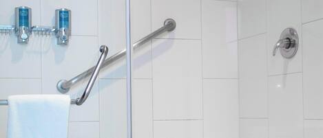 A modern bathroom with a glass shower enclosure, a white toilet, and a towel rack with a towel.
