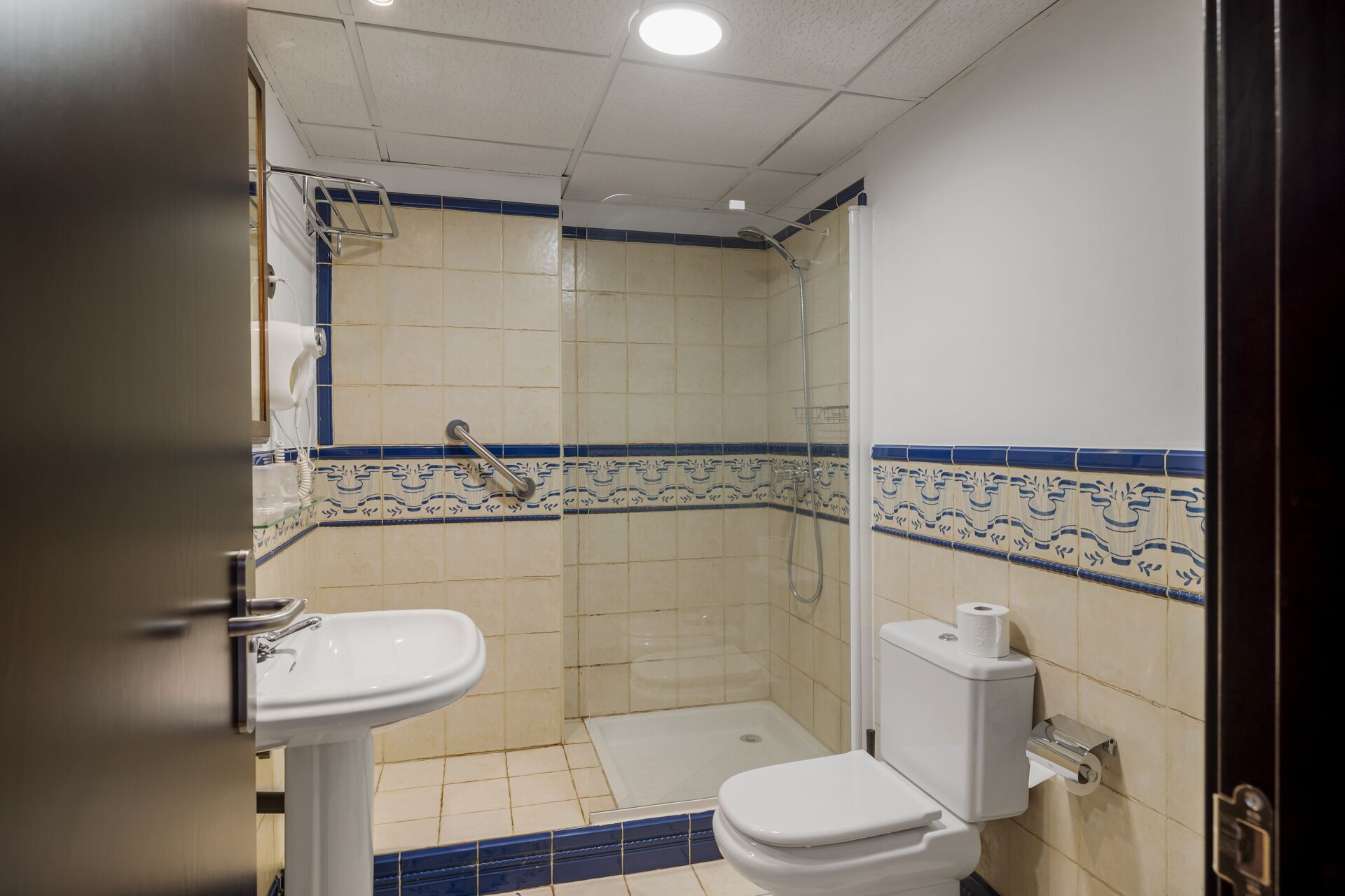 Un baño pequeño con ducha, inodoro y lavabo.