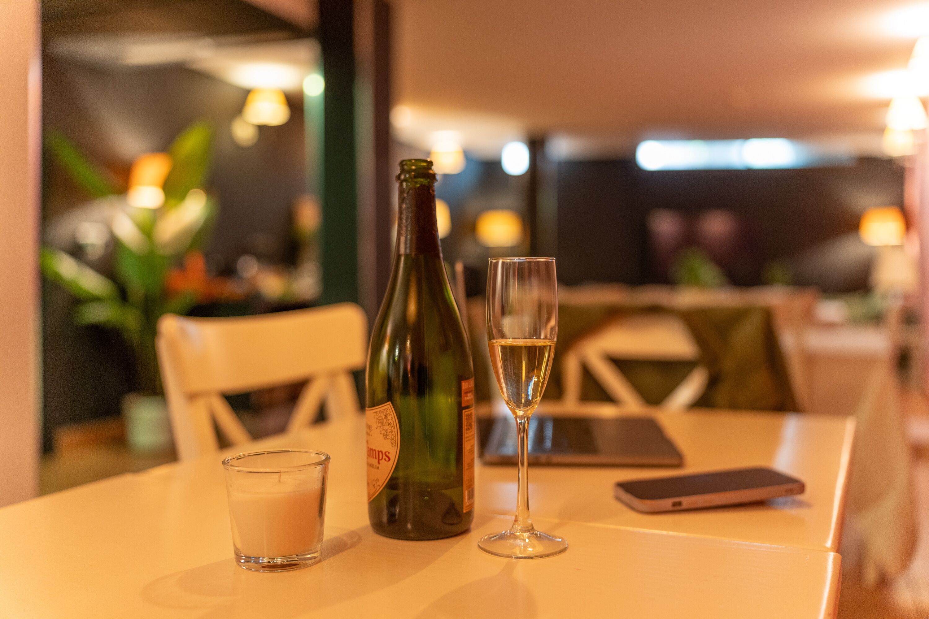 A table with a bottle of wine, a glass of wine, and a glass of milk.
