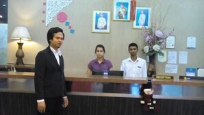 A reception area with a reception desk, a man standing, and two employees behind the desk. - JB Central Hotel (Johor Bahru)