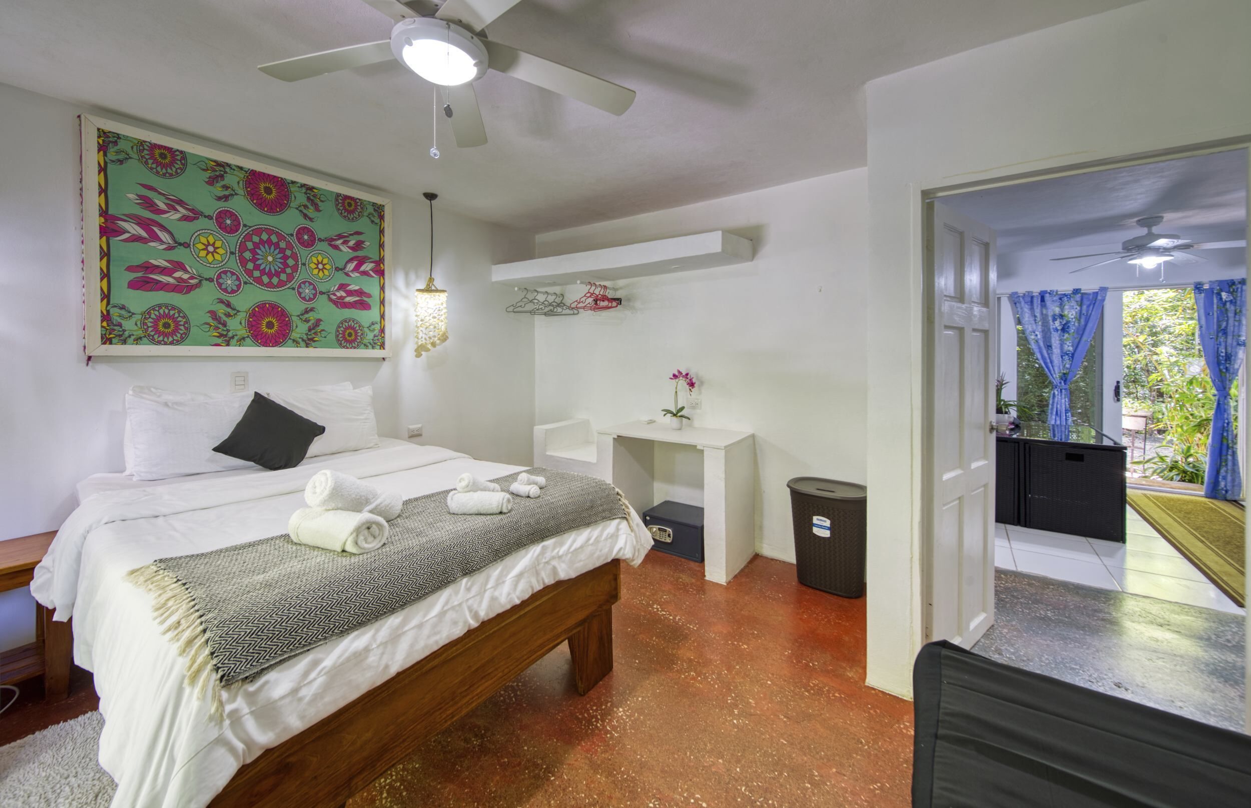 Ein Schlafzimmer mit Bett, Nachttisch und Blick ins Freie.
