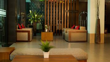 A modern lobby with sofas, a coffee table, and a reception desk.