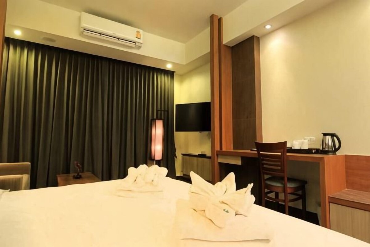 Une chambre d’hôtel équipée d’un lit, d’un bureau, d’une chaise, d’une télévision et d’un appareil de climatisation.
