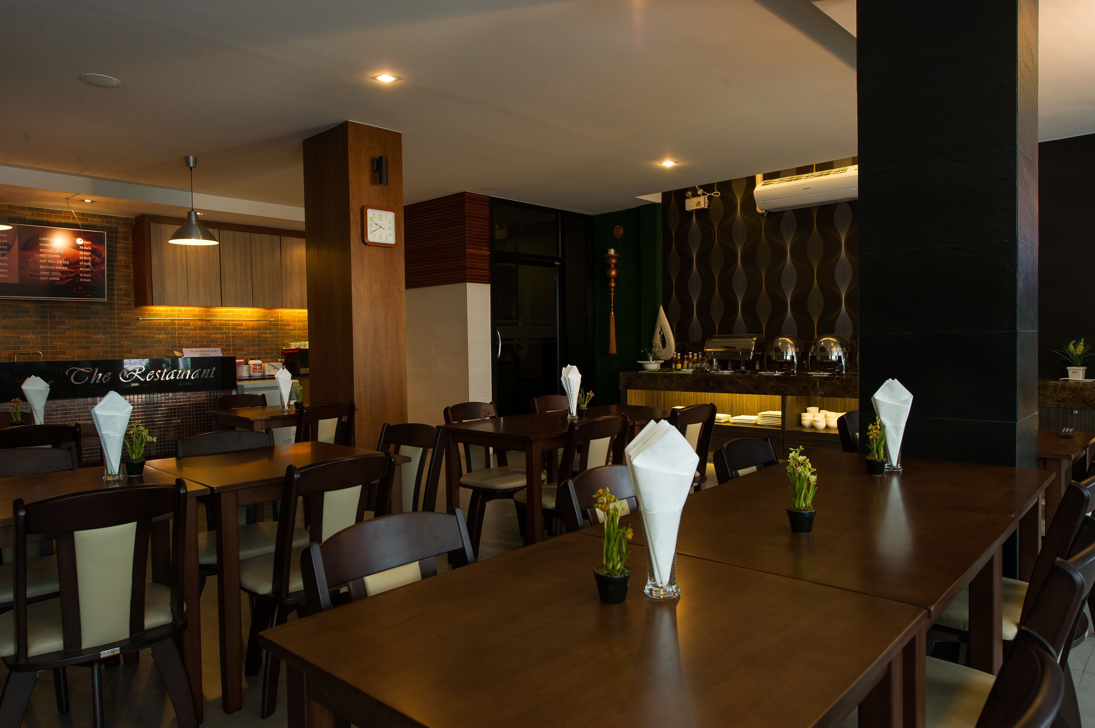 A restaurant with wooden tables and chairs, a bar area, and a menu board.