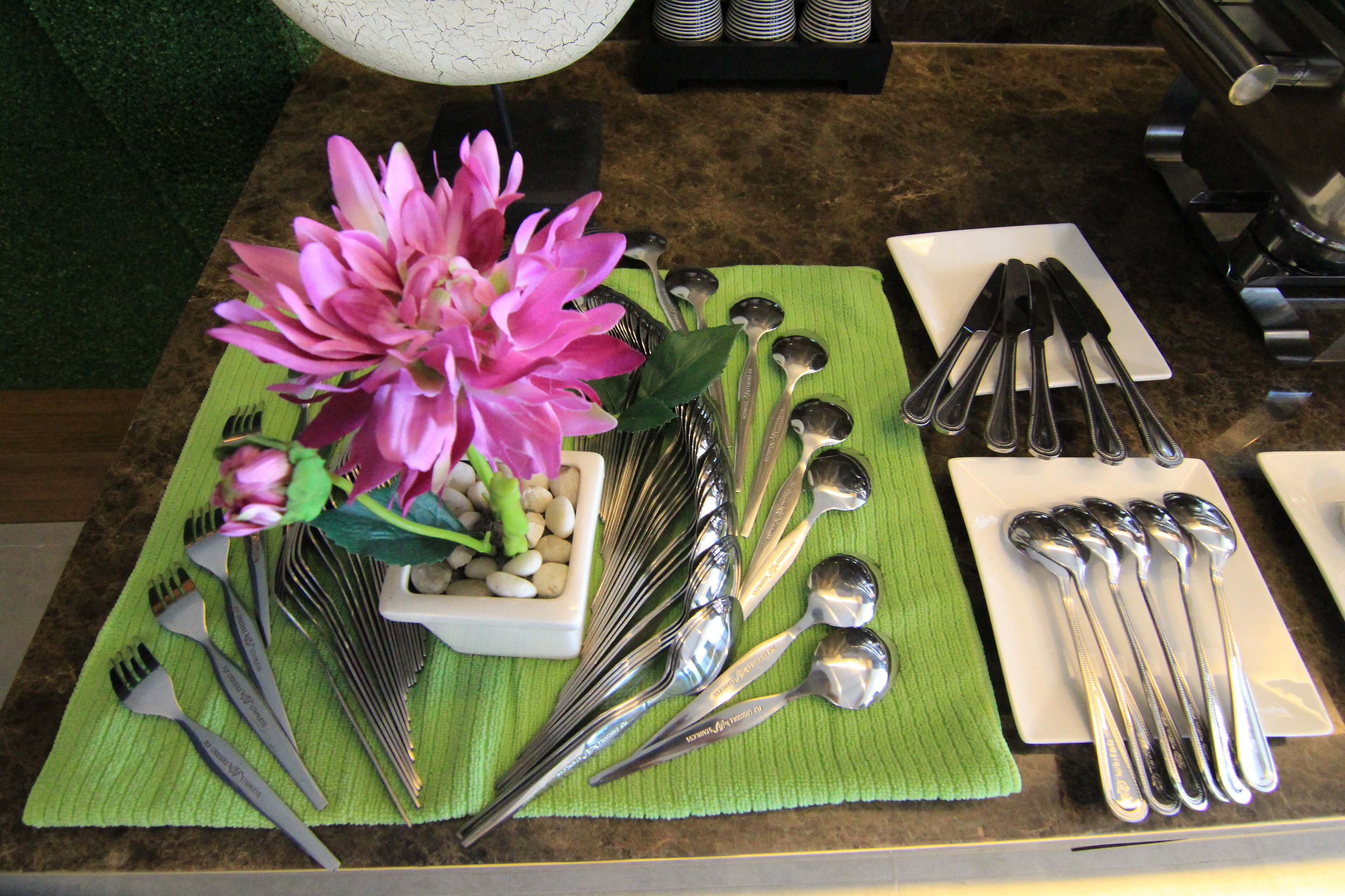 A table set with various utensils and a decorative flower arrangement.
