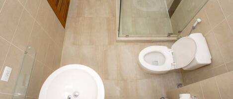 A bathroom with a toilet, sink, and shower.