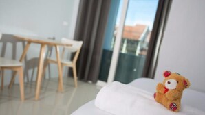 A hotel room with a bed, a small table, and two chairs. - Ruk Cozy Khao Lak (Takua Pa)