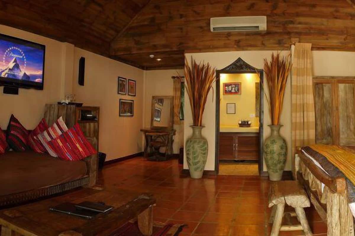 Um quarto acolhedor com uma cama, um sofá e uma televisão.