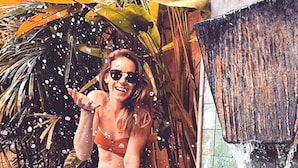 A person sitting on a pool edge with water splashing around.