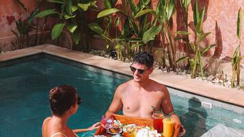 Escena junto a la piscina con una bandeja de comida y bebidas.