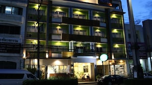 A hotel with multiple balconies, a sign reading "The Greenery Hotel," and a street view with cars and a white van. - The Greenery Hotel (Krabi)